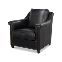 Black leather accent chair angled view with brass studs.