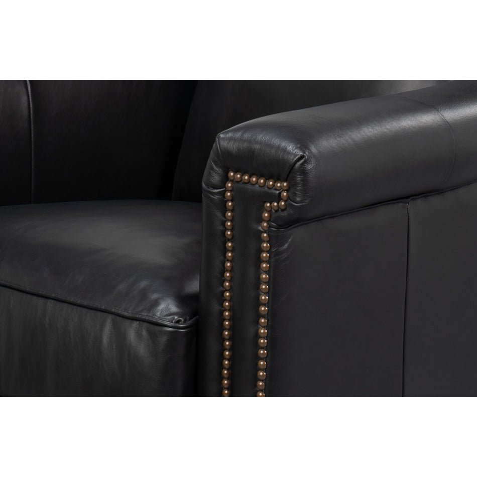 Armrest detail of black leather accent chair with studs.