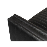 Black leather sofa stitching detail, corner view.