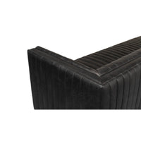 Black leather sofa top corner angle, detailed stitching.