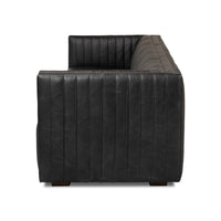 Black leather sofa armrest view, vertical stitching detail.