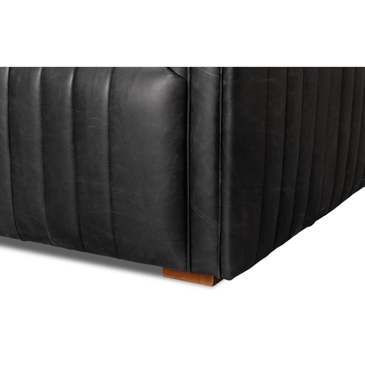 Black leather sofa leg detail, wooden base.