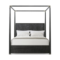 Front view of black canopy bed with pillows.
