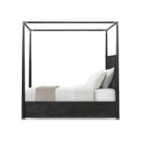 Side view of black canopy bed with cushions.
