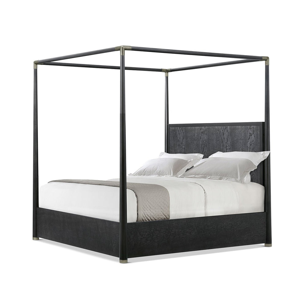 Black canopy bed side angle with white bedding.