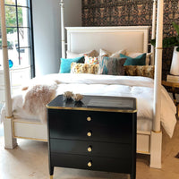 Black mid-century nightstand in stylish bedroom setting.