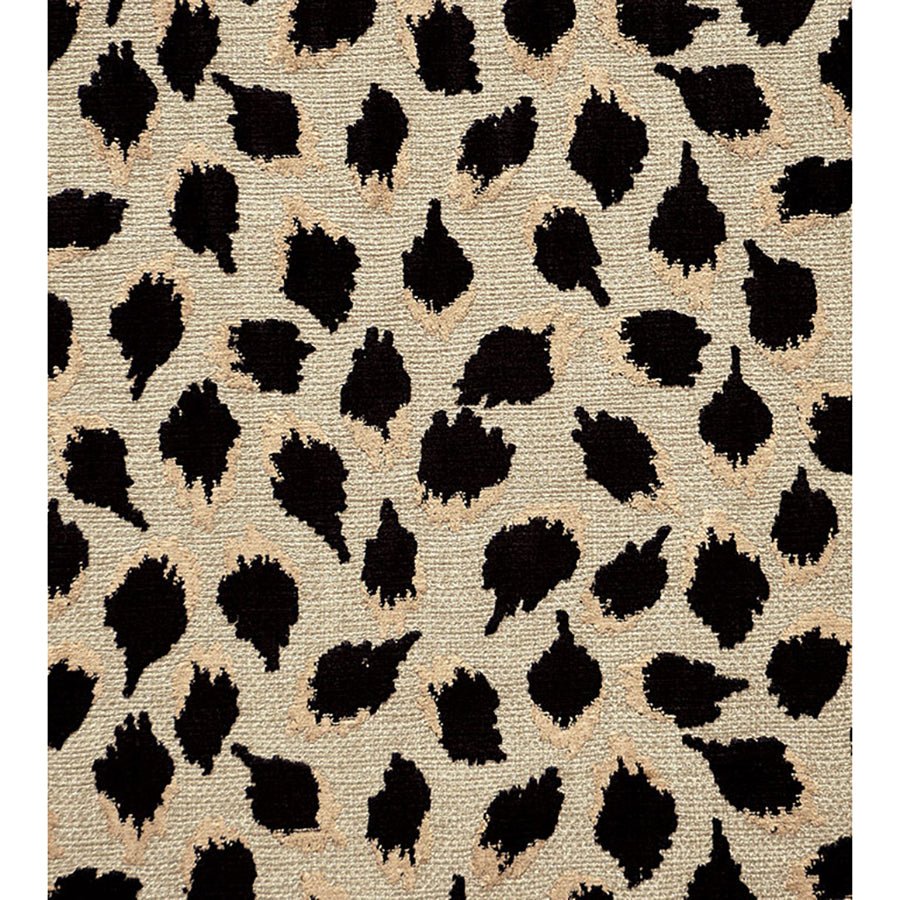 Close-up of black ocelot cube ottoman fabric pattern.