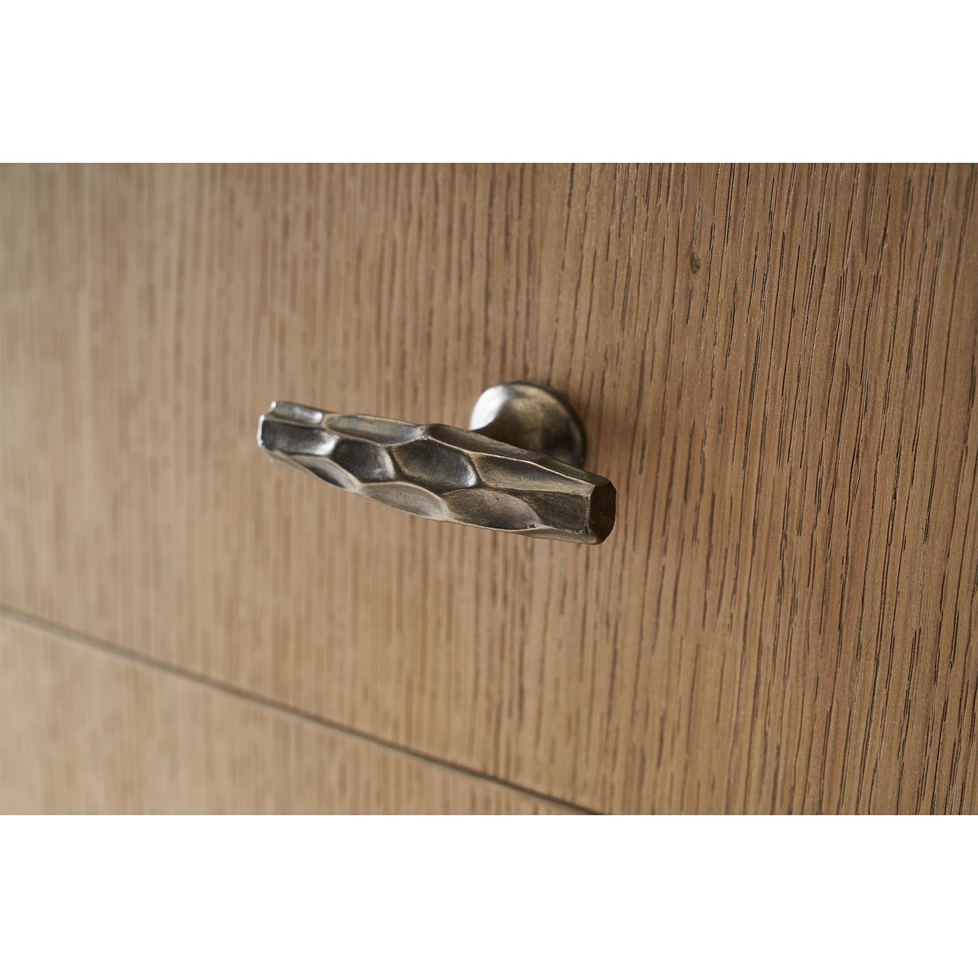Detailed view of buffet drawer handle in metallic finish.