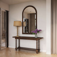 Console table styled in entryway with mirror and lamp.
