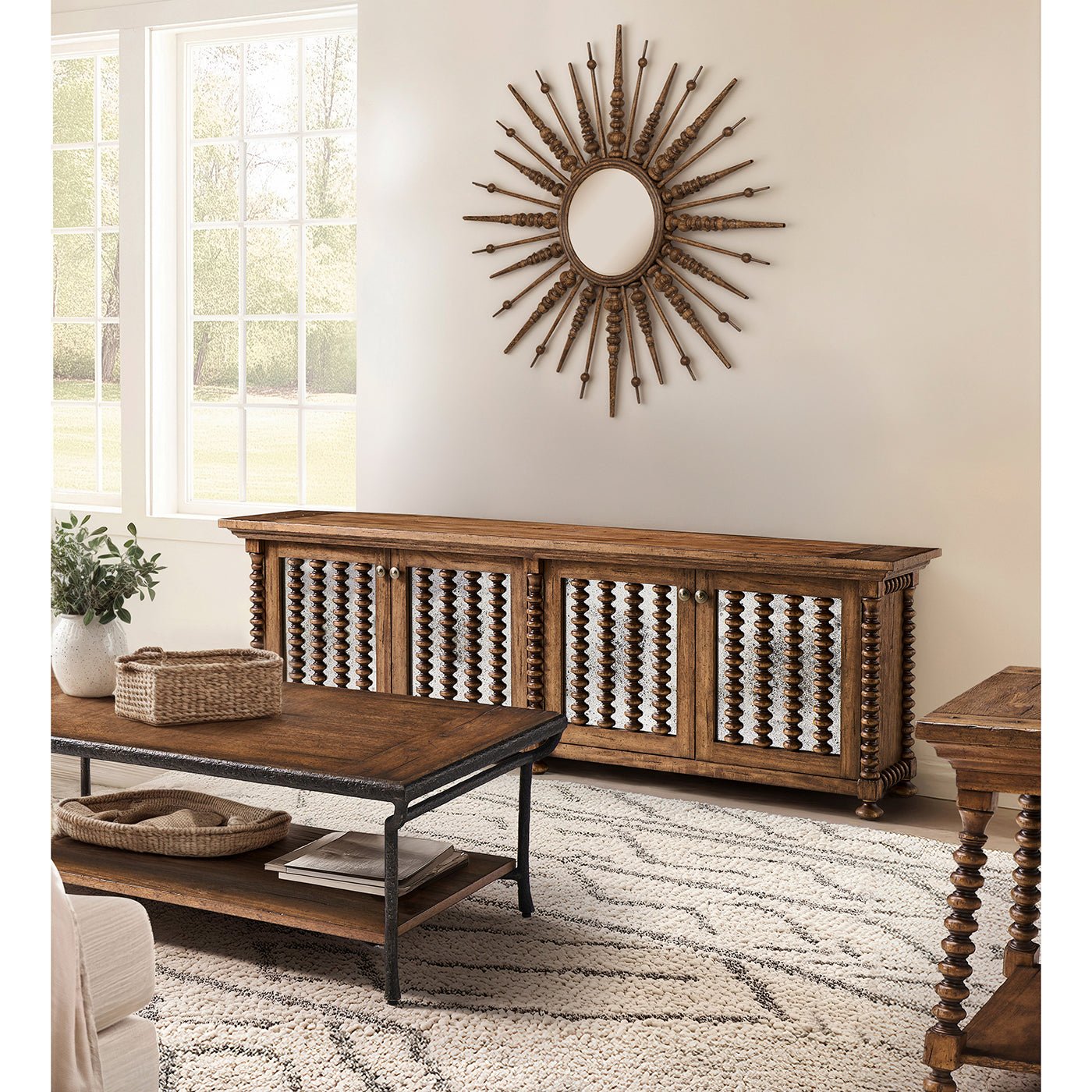Console in living room with sunburst mirror above.