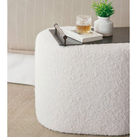 Boucle ottoman used as coffee table with decor.