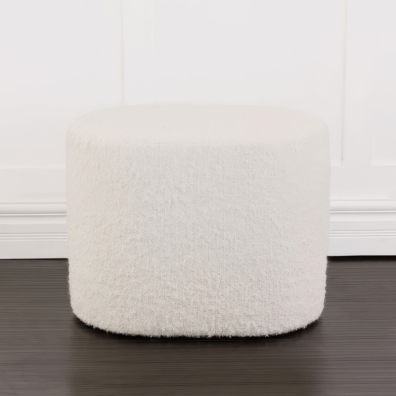 Round boucle ottoman against white background.