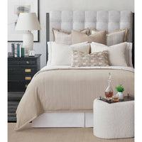 Boucle ottoman in bedroom with bed and decor.