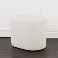 White boucle ottoman in front of white wall.