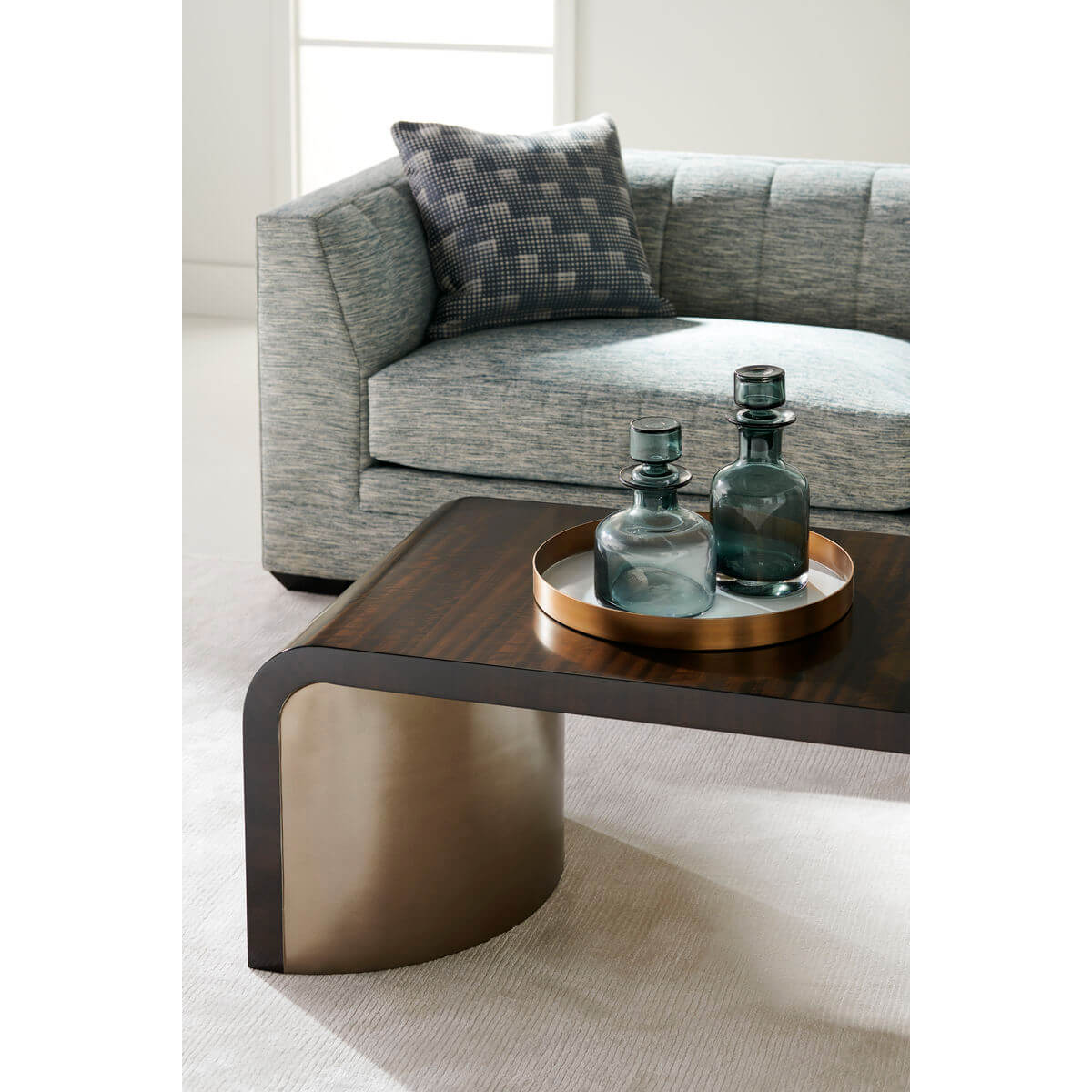 Coffee table with decor, beside gray sofa.