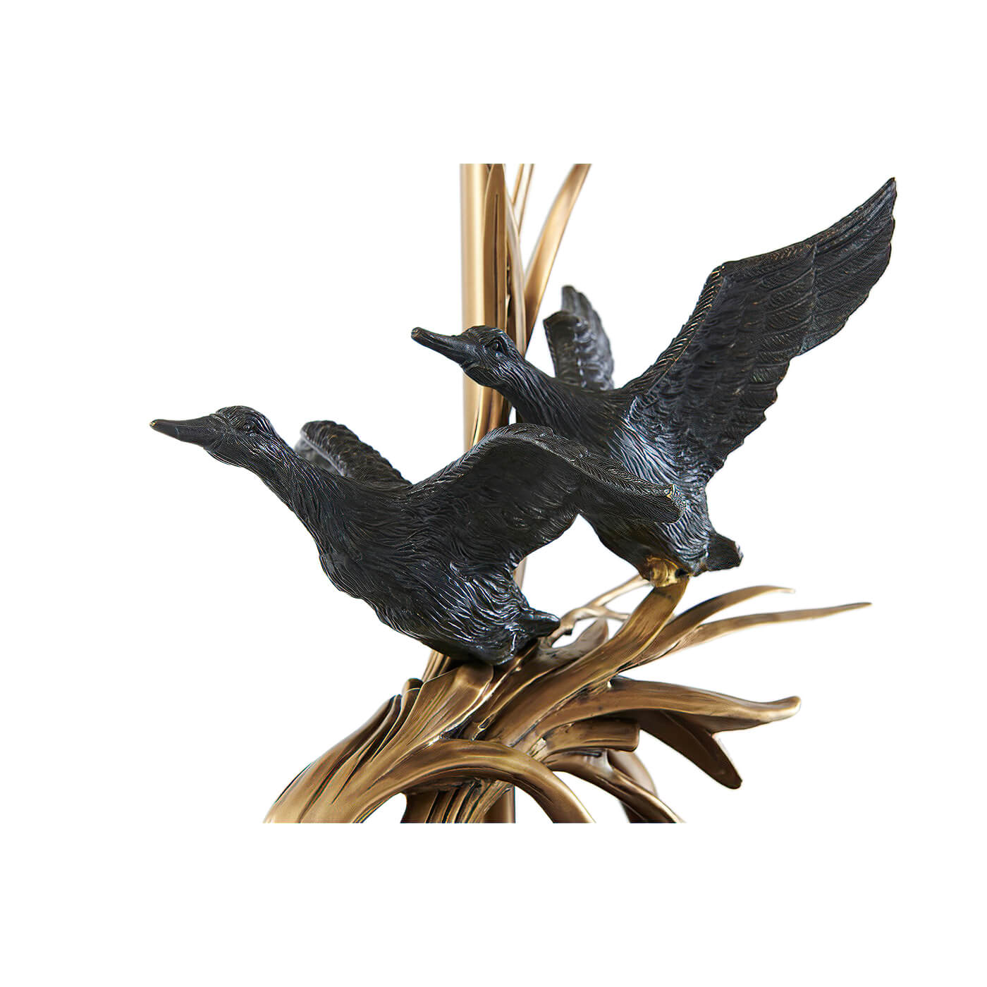 Close-up of brass duck sculptures on lamp base.
