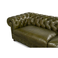 Close-up on Chesterfield sofa corner, deep button tufting.