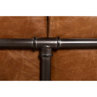Close-up joint detail of industrial leather sofa piping.