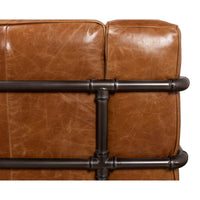 Close-up of metal piping on industrial leather sofa back.