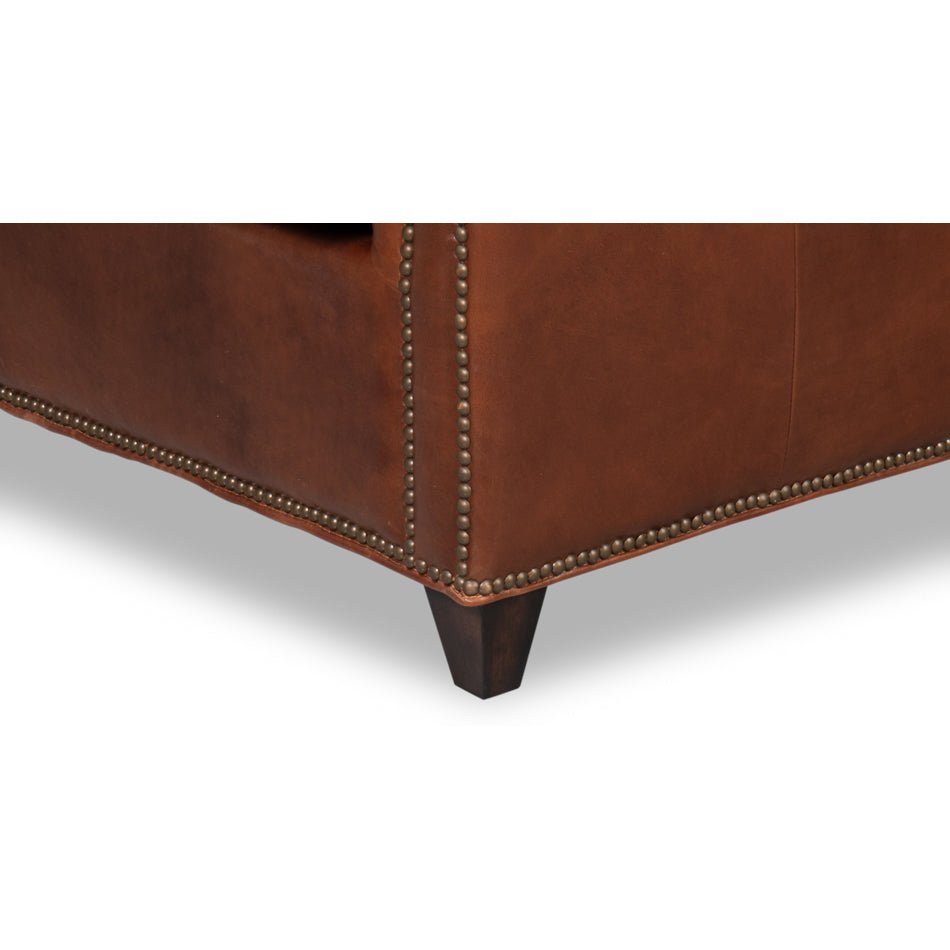 Chair leg and base detailing on brown leather accent chair.