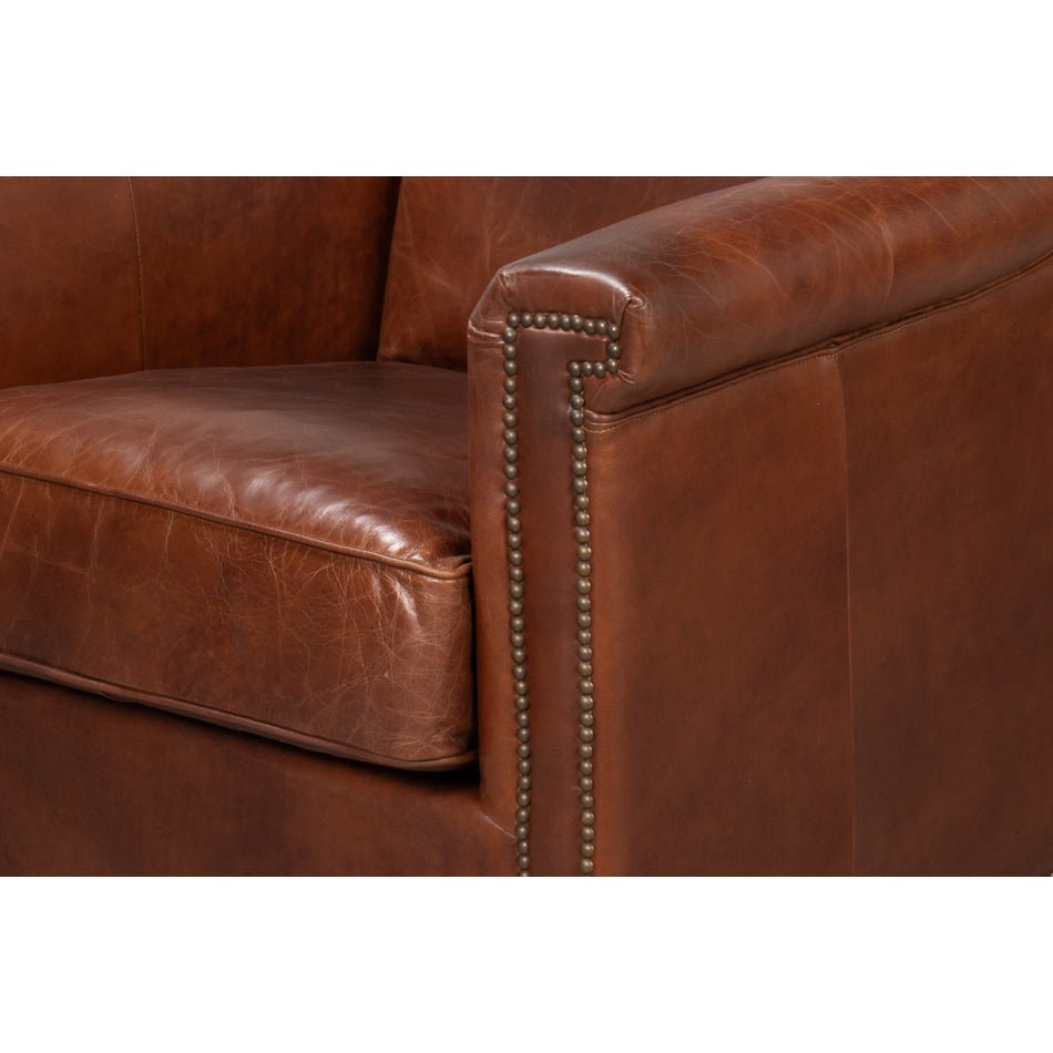 Close-up of armrest with nailhead trim on leather accent chair.