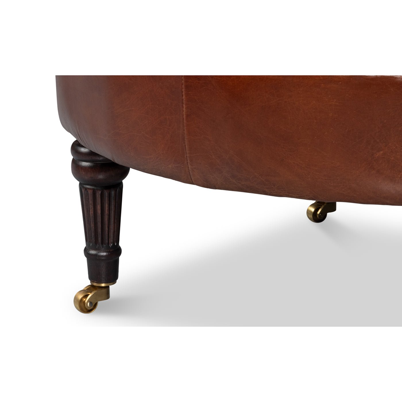 Front leg of brown leather barrel chair with caster.