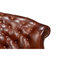 Backrest close-up of brown leather barrel chair.