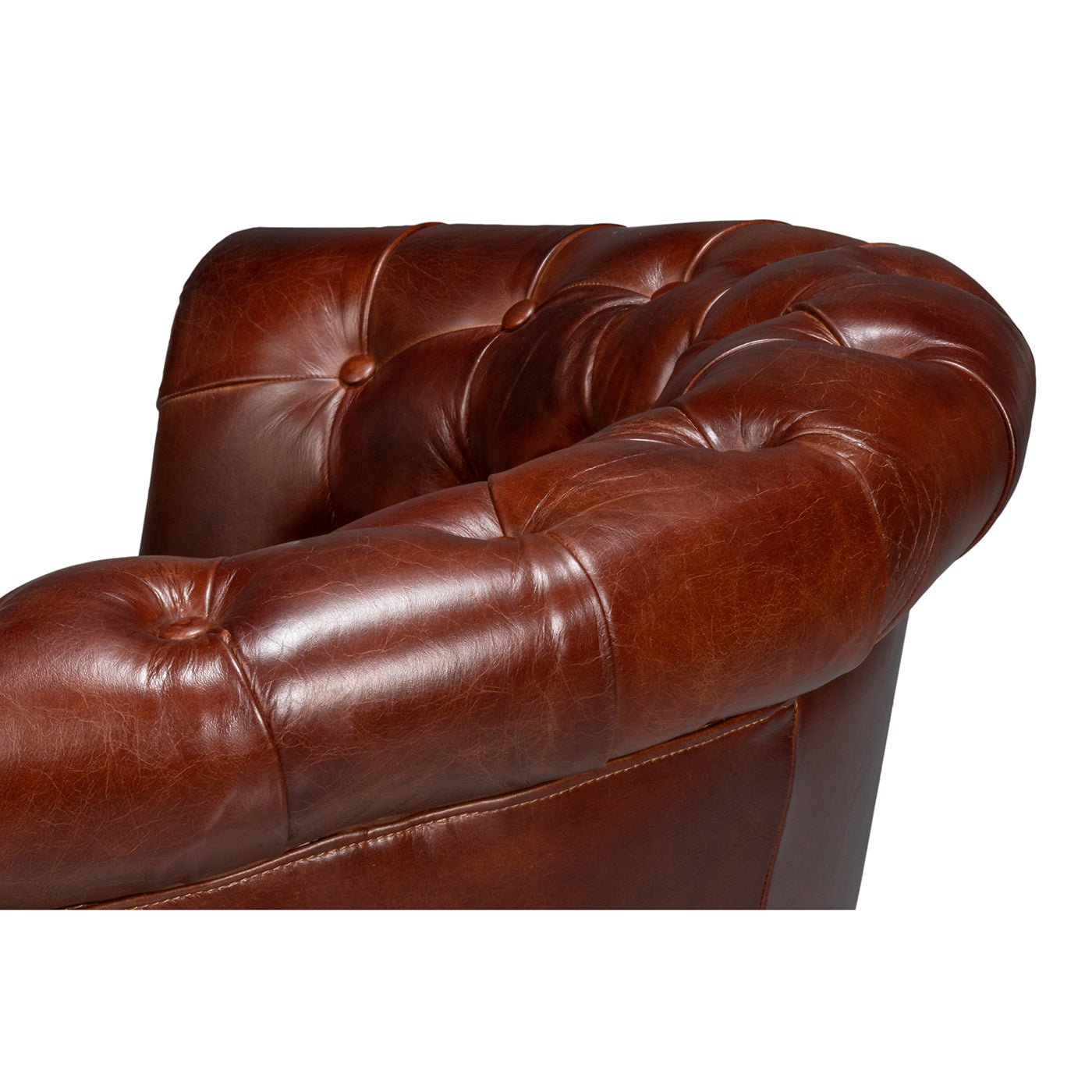 Top back detail of brown leather barrel chair.