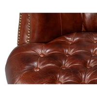 Seat cushion close-up of brown leather barrel chair.