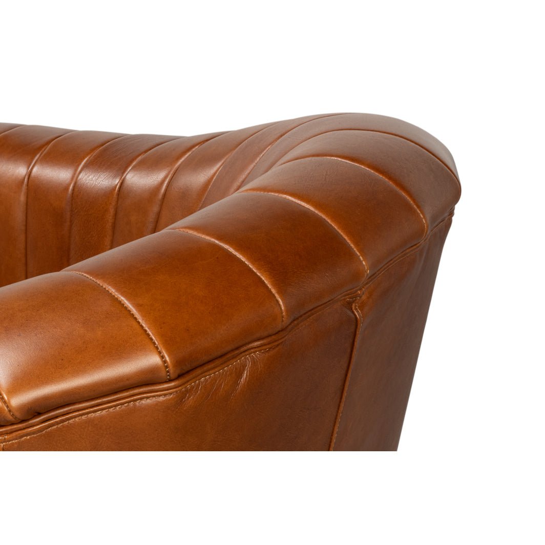 Armrest detail of brown tufted swivel chair.