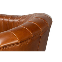 Armrest detail of brown tufted swivel chair.