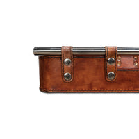 Close-up of brown leather tray corner and handles.
