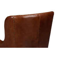 Brown leather wing chair, backrest stitching detail.