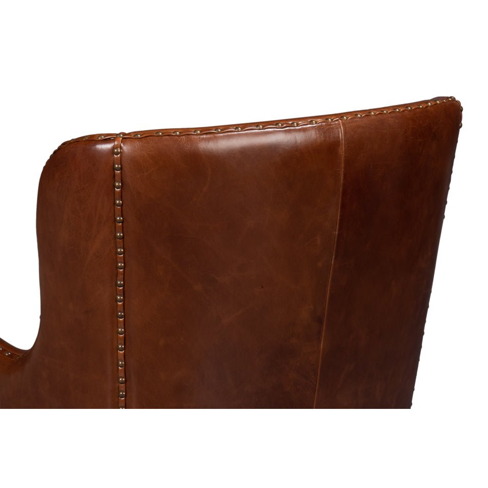 Brown leather wing chair, backrest stitching detail.