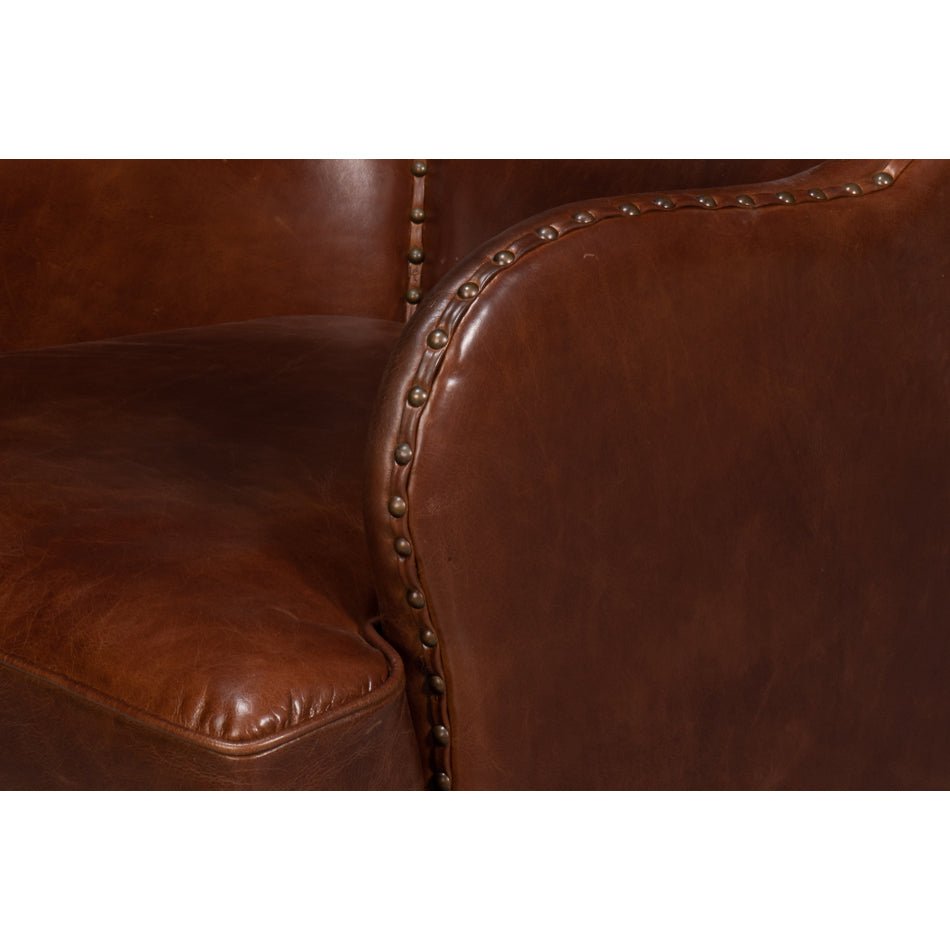 Brown leather wing chair, armrest close-up view.
