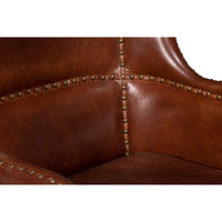 Brown leather wing chair, upholstery stud details.