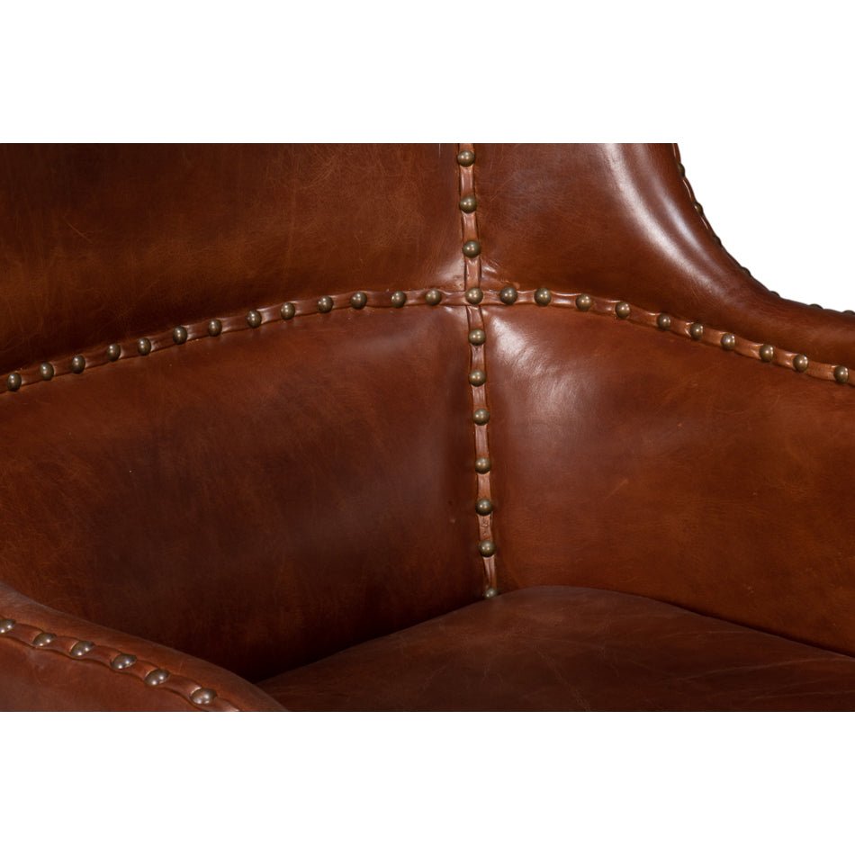 Brown leather wing chair, upholstery stud details.