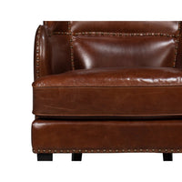 Brown leather wing chair, close-up seat detail.