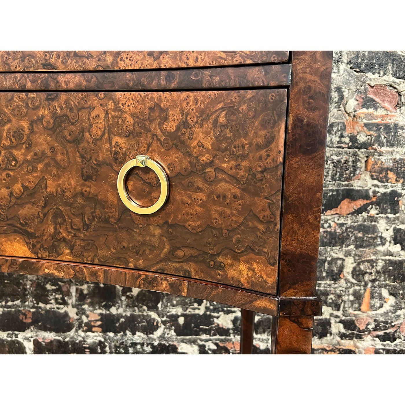 Detailed texture of burl walnut chest with brass ring pull.