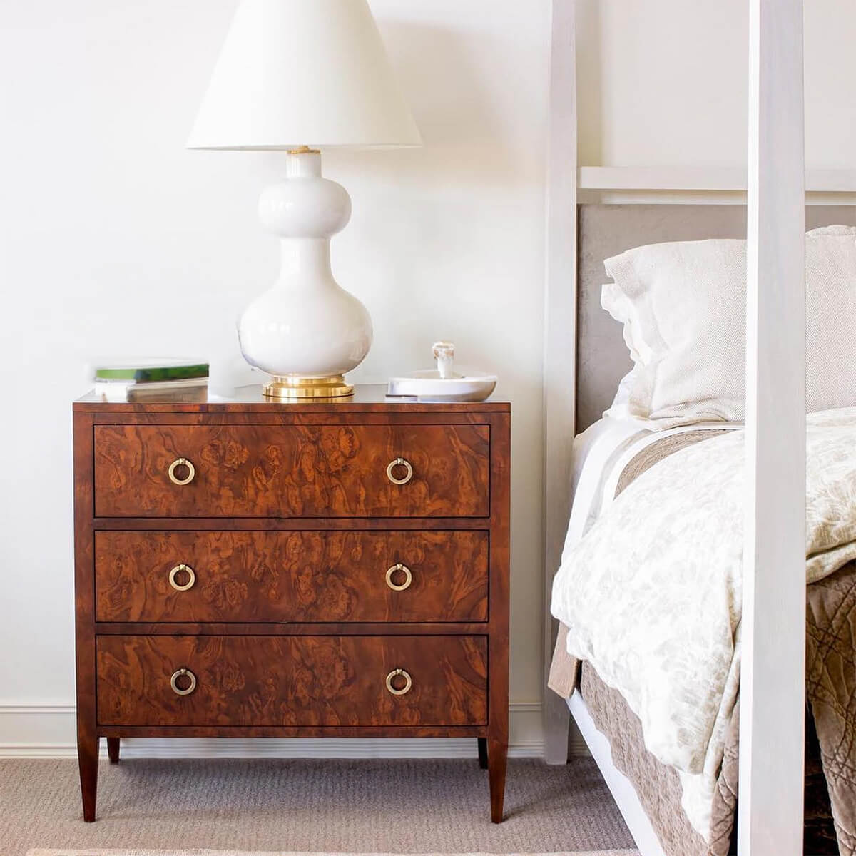 Burl walnut chest in bedroom, lamp and decor.