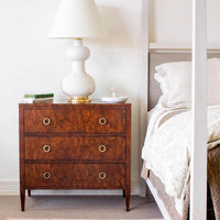 Burl walnut chest in bedroom, lamp and decor.