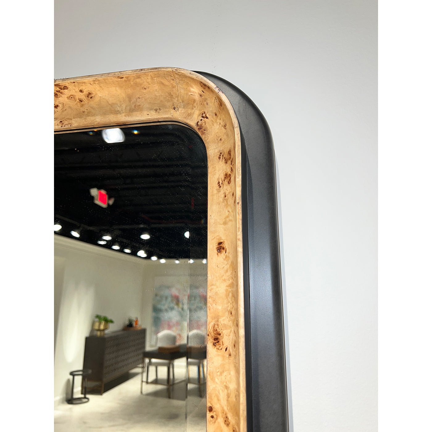 Close-up of mirror corner with burl wood detail.