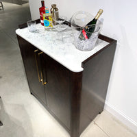 Burl wood bar cabinet with marble top and champagne.