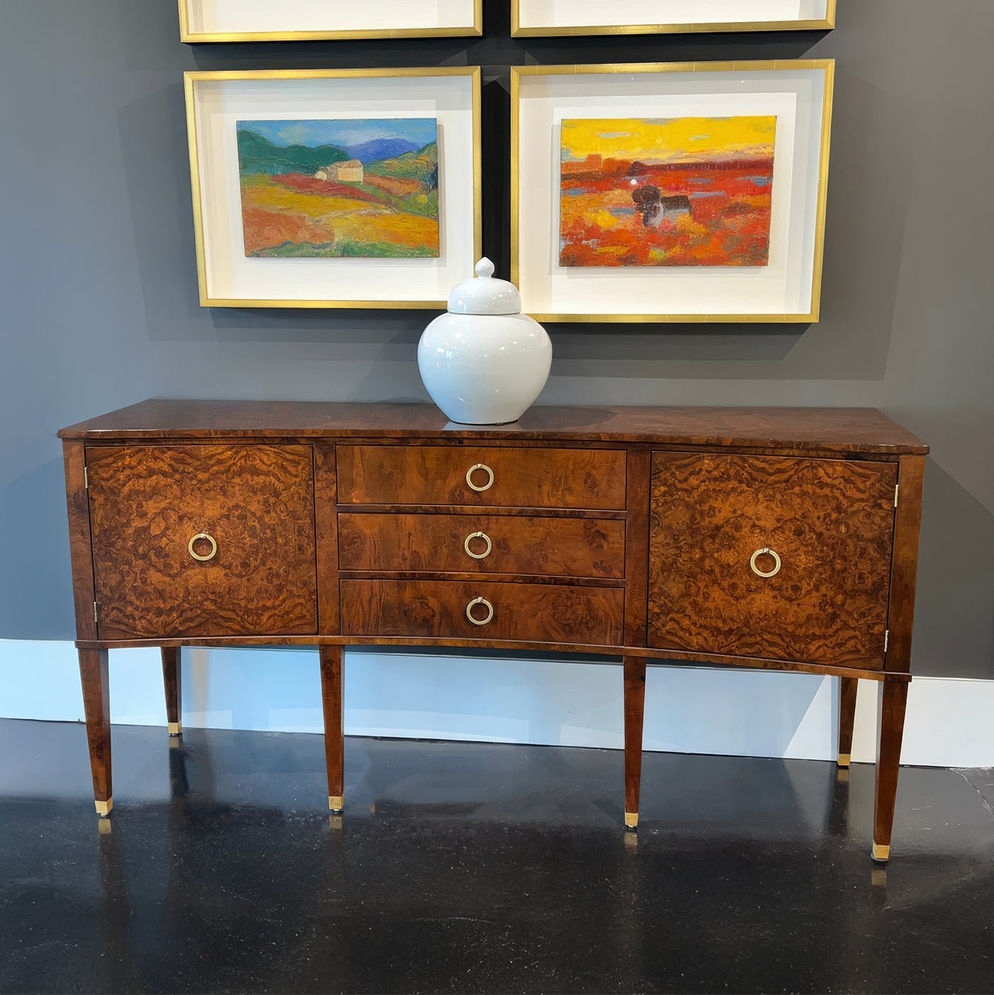 Burl wood sideboard against gray wall, art pieces above.
