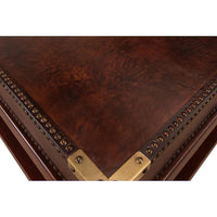 Close-up corner detail, leather coffee table, brass accents.