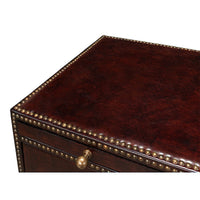 Close-up of top surface, brown campaign dresser, decorative trim.
