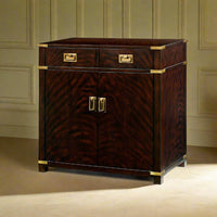 Campaign style mahogany cabinet against paneled wall, front view.