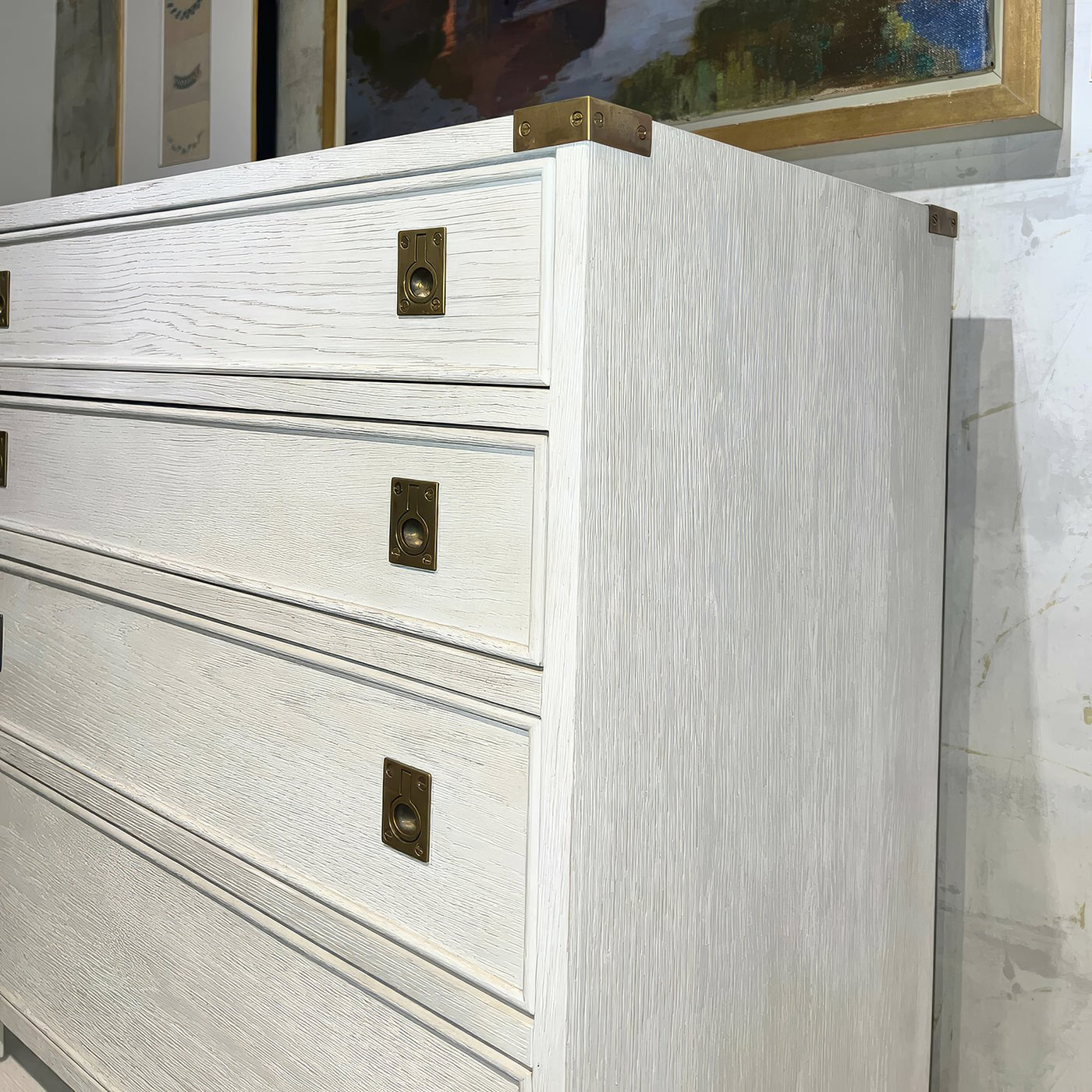 Side view of campaign style nightstand with brass hardware.