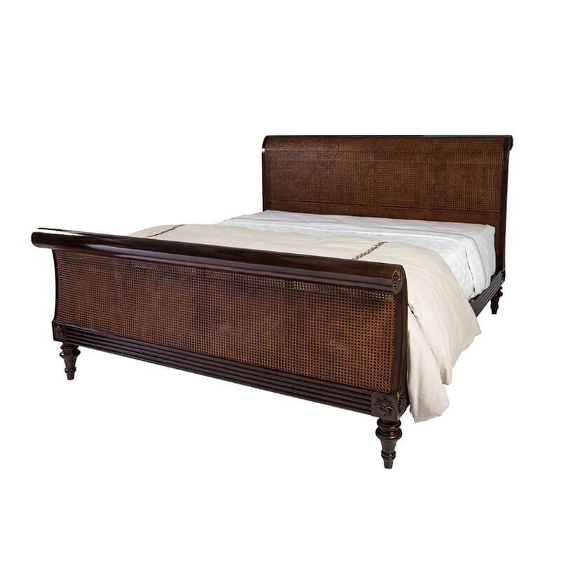 Sleigh bed with cane detailing, side view.