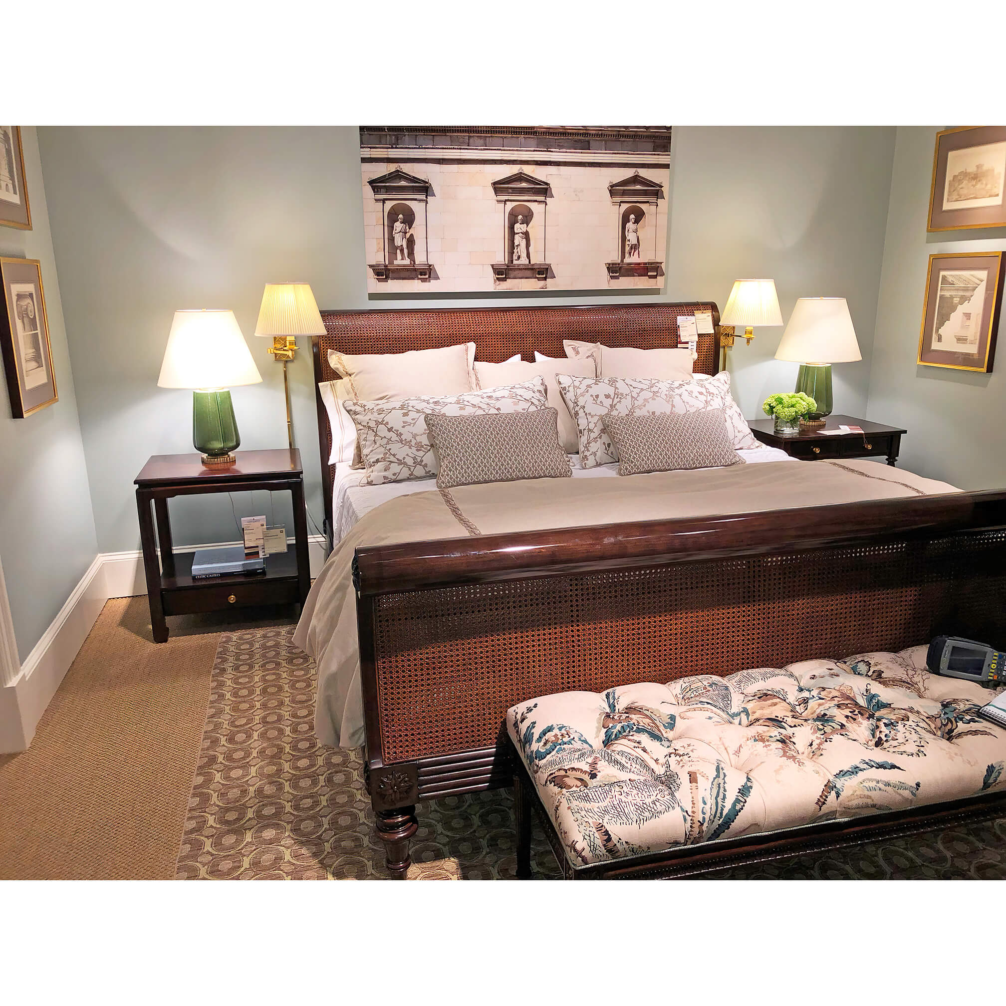 Sleigh bed in decorated room with lamps and bench.